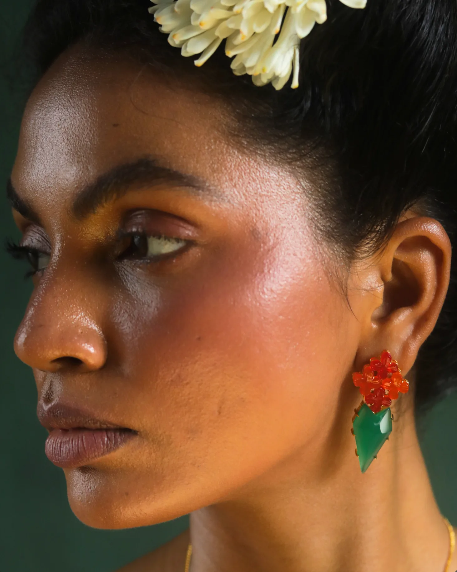 A pair of jhumkas resting on raw silk